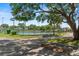 Community tennis court surrounded by mature trees and well-maintained landscaping at 628 Olympic Dr # 8-C, Ocoee, FL 34761