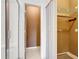 Bathroom view showing the shower and closet/toilet room entrance with tiling, shower door, and closet shelving at 709 Orchid Dr, Davenport, FL 33897