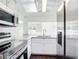 Modern kitchen featuring stainless steel appliances, white cabinetry, and granite countertops at 709 Orchid Dr, Davenport, FL 33897