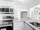 Modern kitchen featuring stainless steel appliances, white cabinetry, and granite countertops at 709 Orchid Dr, Davenport, FL 33897