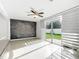 Bright living room with a stylish brick accent wall, ceiling fan, and sliding glass doors at 709 Orchid Dr, Davenport, FL 33897