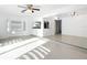 Spacious living area with sleek tiled floors, ceiling fan, and adjacent kitchen pass-through at 709 Orchid Dr, Davenport, FL 33897