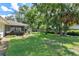 Lush backyard with green grass, trees, and a screened-in patio at 73 Alano Rd, Debary, FL 32713