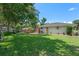 Spacious backyard featuring lush green grass, mature trees, a deck, and ample space for outdoor activities at 73 Alano Rd, Debary, FL 32713