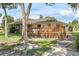 Backyard featuring a wooden deck, lush greenery, mature trees, and a well-manicured lawn, perfect for relaxing at 73 Alano Rd, Debary, FL 32713