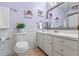 Cozy bathroom featuring white cabinets, a toilet, and floral decorations at 73 Alano Rd, Debary, FL 32713