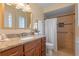 Bright bathroom featuring a granite vanity top, wooden cabinets, and a tiled shower at 73 Alano Rd, Debary, FL 32713