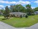 A corner lot showing the manicured lawn of a single-story home flying the American flag at 73 Alano Rd, Debary, FL 32713