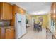 Open kitchen layout with natural wood cabinets, granite counters, and adjacent dining area at 73 Alano Rd, Debary, FL 32713