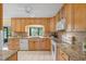 Bright kitchen showcasing granite countertops and natural wood cabinets with modern appliances at 73 Alano Rd, Debary, FL 32713