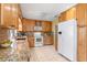 Well-lit kitchen featuring granite countertops, wood cabinets, and stainless steel appliances at 73 Alano Rd, Debary, FL 32713