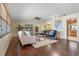 Open-concept living room featuring hardwood floors, plush rug, and easy access to the kitchen and dining area at 73 Alano Rd, Debary, FL 32713