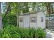 Backyard storage shed surrounded by lush ferns and mature trees, offering convenient outdoor storage at 73 Alano Rd, Debary, FL 32713