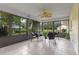 Enclosed sunroom featuring a ceiling fan, tile flooring, and large windows offering a scenic view at 73 Alano Rd, Debary, FL 32713