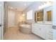 Bright bathroom featuring double vanities, a soaking tub, tile floors, and a separate tiled shower stall at 7388 John Hancock Dr, Winter Garden, FL 34787