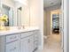 Clean bathroom with a white vanity, large mirror, and access to additional rooms at 7388 John Hancock Dr, Winter Garden, FL 34787