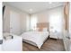Bright bedroom featuring a queen bed, white nightstands, white doors and wood floors at 7388 John Hancock Dr, Winter Garden, FL 34787
