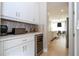 Butler's pantry with custom cabinets, wine refrigerator, and view towards the kitchen and dining area at 7388 John Hancock Dr, Winter Garden, FL 34787