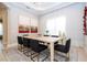 Dining room featuring a table with black chairs and modern decor, complemented by a large window and stylish artwork at 7388 John Hancock Dr, Winter Garden, FL 34787