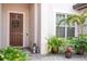 Inviting front entrance with a wreath on the door and tropical plants at 7388 John Hancock Dr, Winter Garden, FL 34787