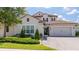 Charming two-story home featuring a tile roof, a brick paved driveway, and manicured landscaping at 7388 John Hancock Dr, Winter Garden, FL 34787