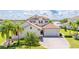 Beautiful two-story home with lush landscaping, a tile roof, and waterfront views at 7388 John Hancock Dr, Winter Garden, FL 34787