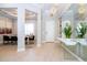 Bright foyer with white door, modern chandelier, mirrored wall, and elegant table with floral arrangement at 7388 John Hancock Dr, Winter Garden, FL 34787