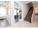 Bright hallway with stairs, tile floors, and views into a home office and laundry room through the doorways at 7388 John Hancock Dr, Winter Garden, FL 34787