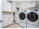 A clean, well-organized laundry room features modern washer and dryer appliances and built-in cabinets and counter space at 7388 John Hancock Dr, Winter Garden, FL 34787