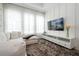 A modern living room features a large TV, white entertainment center, and plush carpeting beneath a comfortable sectional sofa at 7388 John Hancock Dr, Winter Garden, FL 34787
