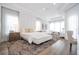 Elegant bedroom with a tray ceiling, stylish furniture, and abundant natural light at 7388 John Hancock Dr, Winter Garden, FL 34787