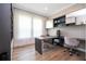 A bright home office features a sleek desk, comfortable chairs, and ample natural light from the large windows at 7388 John Hancock Dr, Winter Garden, FL 34787