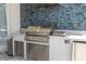 This outdoor kitchen features a stainless steel grill, sink, and ample counter space at 7388 John Hancock Dr, Winter Garden, FL 34787