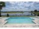 Sparkling pool overlooking a serene lake, complemented by a picturesque landscape at 7388 John Hancock Dr, Winter Garden, FL 34787