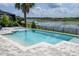 Beautiful pool with a serene lake view, palm trees, and ample patio space for relaxation at 7388 John Hancock Dr, Winter Garden, FL 34787