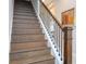 Elegant staircase features wood stairs, decorative handrail and a bright hallway at 7388 John Hancock Dr, Winter Garden, FL 34787