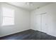 Bedroom featuring dark wood flooring, closet with sliding doors and a large window at 7557 Azalea Cove Cir, Orlando, FL 32807