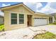 Beautiful home exterior featuring manicured landscaping and a two-car garage at 7557 Azalea Cove Cir, Orlando, FL 32807