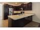 Kitchen featuring dark brown cabinets, stainless steel appliances and a breakfast bar at 7557 Azalea Cove Cir, Orlando, FL 32807