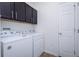 A clean laundry room with updated washer and dryer, along with dark cabinets, and a clean neutral paint at 7557 Azalea Cove Cir, Orlando, FL 32807