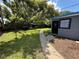 A lush backyard with a grey house and walkway at 7709 Ravenna Ave, Orlando, FL 32819