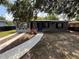 Charming home exterior with a tidy yard, blue front door, and freshly painted gray facade at 7709 Ravenna Ave, Orlando, FL 32819