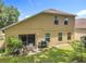 This backyard features a table with chairs, a grill, and a sliding glass door at 7939 Riffle Ln, Orlando, FL 32818