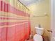 This bathroom features a toilet, a wastebasket, a towel rack, and a shower with a curtain at 7939 Riffle Ln, Orlando, FL 32818
