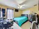 This bedroom features a ceiling fan, a TV, a window, a closet, and a bed with a blue comforter at 7939 Riffle Ln, Orlando, FL 32818