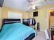 This bedroom features a ceiling fan, a closet, a dresser, a stand with clothes hanging, and a bed with a blue comforter at 7939 Riffle Ln, Orlando, FL 32818