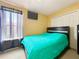 This bedroom features a ceiling fan, a window, a closet, a TV, and a bed with a blue comforter at 7939 Riffle Ln, Orlando, FL 32818