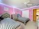 Bright bedroom with striped beds, ceiling fan, pink walls, and built-in closet at 7939 Riffle Ln, Orlando, FL 32818