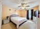This bedroom features a ceiling fan, a window, a nightstand, and a bed with a white comforter at 7939 Riffle Ln, Orlando, FL 32818
