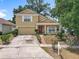 Charming two-story home with a red front door, well-maintained lawn, and attached two-car garage at 7939 Riffle Ln, Orlando, FL 32818